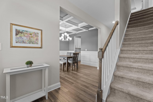 5 Cinnamon Teal Way, Youngsville, NC 27596 - stairway with coffered ceiling, beam ceiling, a chandelier, wood finished floors, and wainscoting