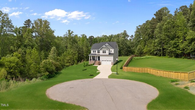 5 Cinnamon Teal Way, Youngsville, NC 27596 - view of community with curved driveway, an attached garage, a lawn, and a view of trees