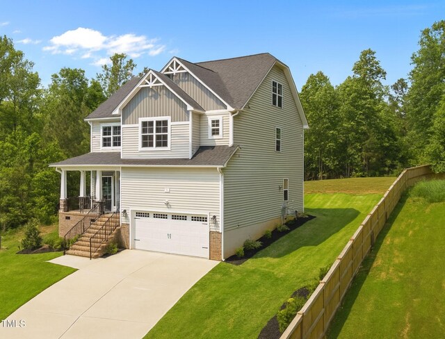 5 Cinnamon Teal Way, Youngsville, NC 27596 - craftsman house featuring board and batten siding, an attached garage, driveway, a front yard, and a shingled roof