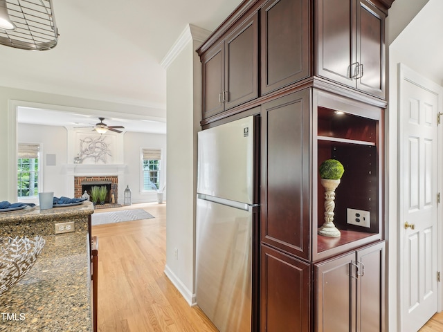 113 Bergeron Way, Cary, NC 27519 - kitchen with freestanding refrigerator, ceiling fan, light wood-type flooring, a brick fireplace, and dark stone countertops
