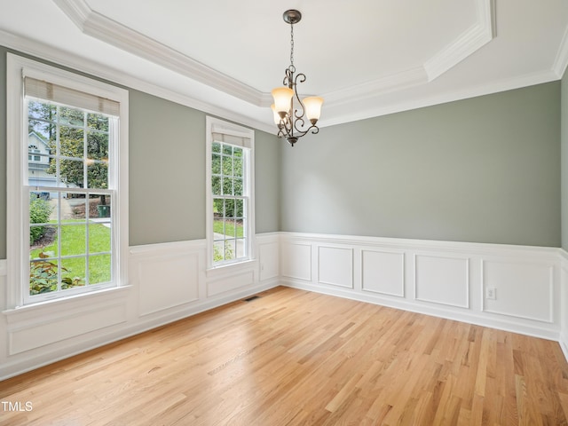 113 Bergeron Way, Cary, NC 27519 - empty room with a chandelier, a raised ceiling, crown molding, light wood-style flooring, and wainscoting