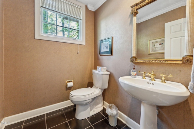 half bath featuring crown molding, toilet, tile patterned flooring, and baseboards