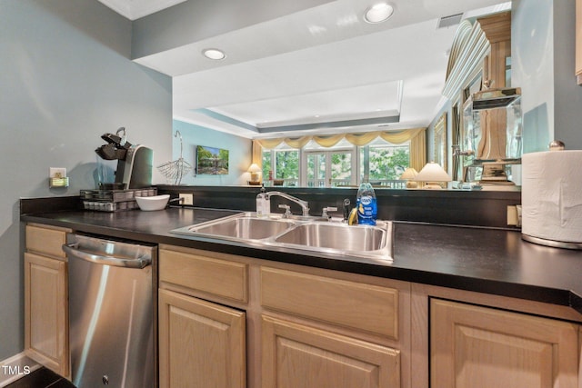 kitchen featuring dishwasher, a sink, dark countertops, a raised ceiling, and recessed lighting