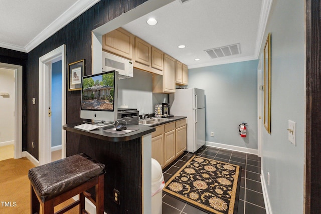 kitchen featuring white appliances, dark countertops, crown molding, dark tile patterned flooring, and baseboards