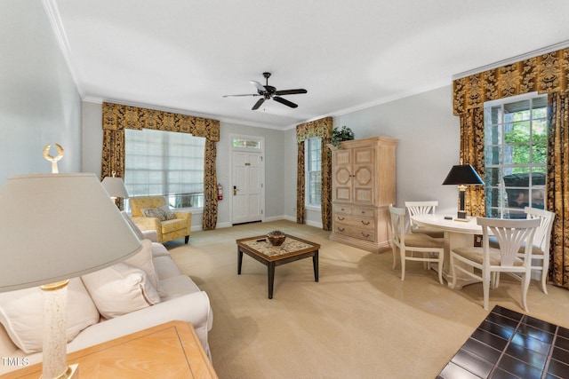 carpeted living area featuring ornamental molding, a ceiling fan, healthy amount of natural light, and baseboards