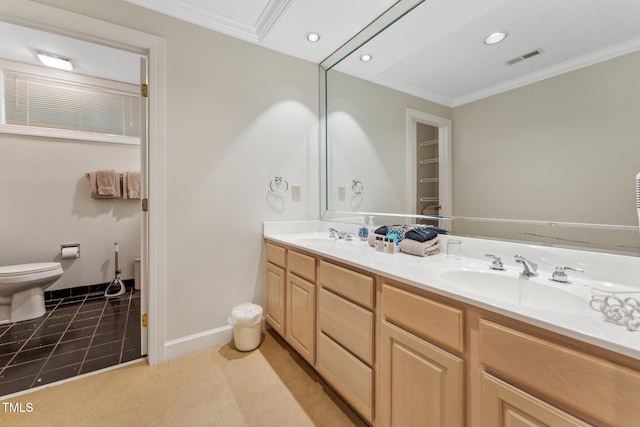 bathroom featuring toilet, crown molding, double vanity, recessed lighting, and baseboards