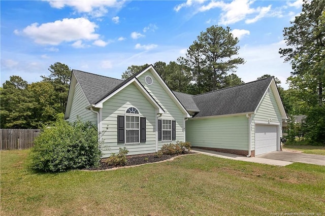 view of front facade with fence, a shingled roof, a garage, a front yard, and driveway