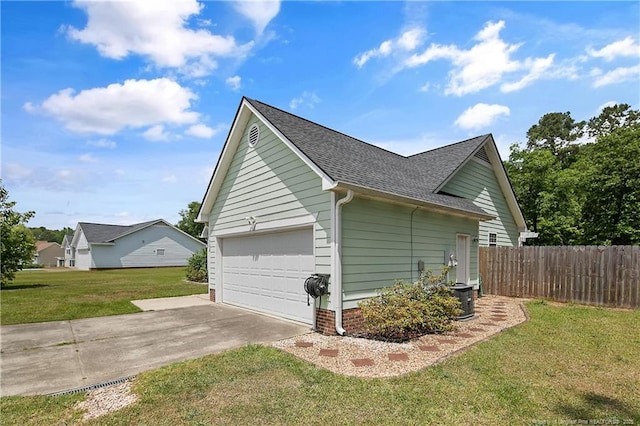 view of side of home featuring fence, a shingled roof, a garage, a yard, and driveway