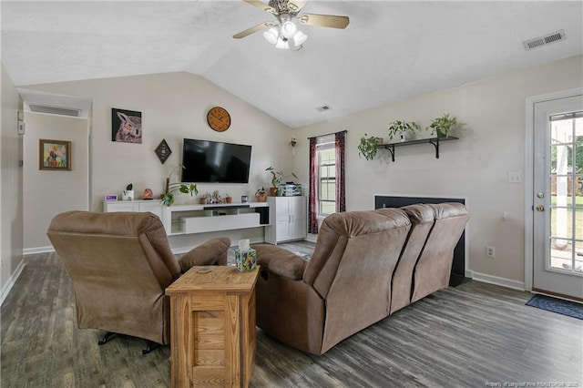 living area with baseboards, lofted ceiling, wood finished floors, and visible vents
