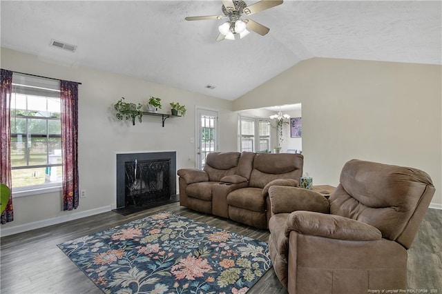 living area with visible vents, a textured ceiling, lofted ceiling, and wood finished floors