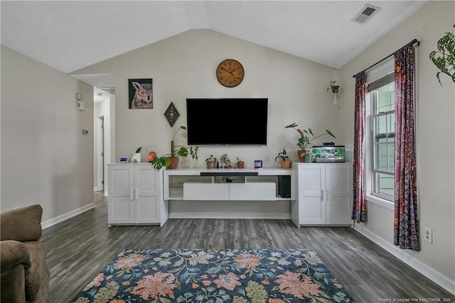 living area featuring visible vents, lofted ceiling, a healthy amount of sunlight, baseboards, and dark wood-type flooring