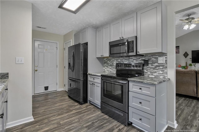 kitchen with baseboards, backsplash, stainless steel appliances, and dark wood-style floors