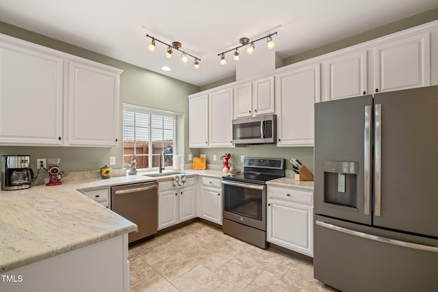 kitchen featuring white cabinets, light countertops, stainless steel appliances, and a sink