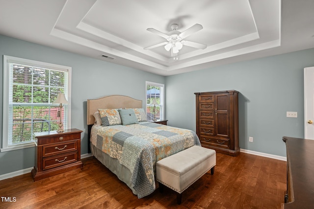 bedroom with baseboards, a raised ceiling, visible vents, and dark wood-type flooring