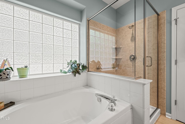 bathroom featuring a bath and a shower stall