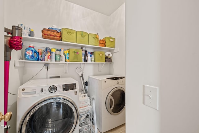 clothes washing area with washer and clothes dryer, laundry area, and light tile patterned floors