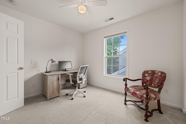 office area featuring light colored carpet, baseboards, a ceiling fan, and visible vents