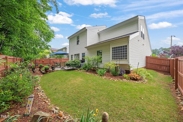 back of property with a fenced backyard, a patio, and a lawn