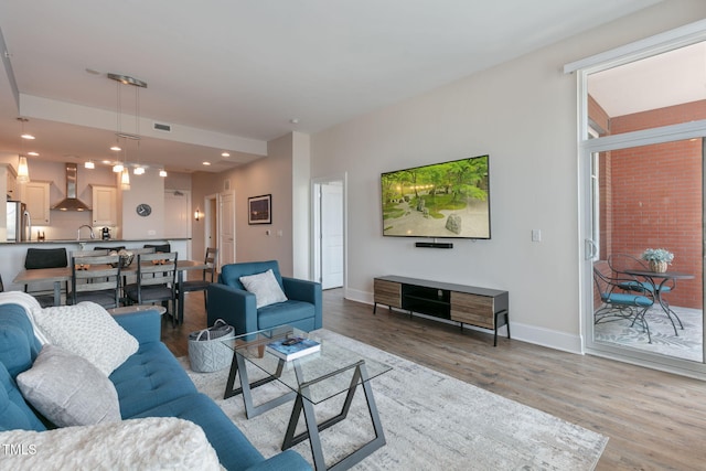 living area featuring baseboards, recessed lighting, wood finished floors, and visible vents