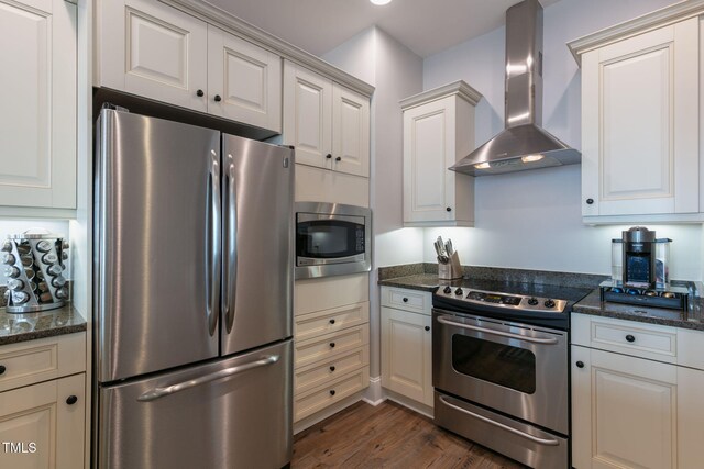 400 W N St Unit 1134, Raleigh, NC 27603 - kitchen featuring dark wood-type flooring, dark stone counters, wall chimney range hood, and stainless steel appliances