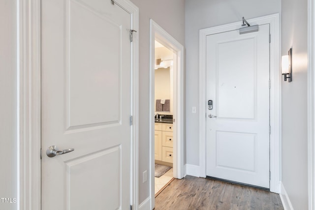 entryway featuring baseboards and light wood finished floors