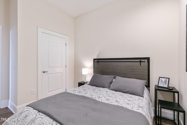 bedroom featuring baseboards and wood finished floors