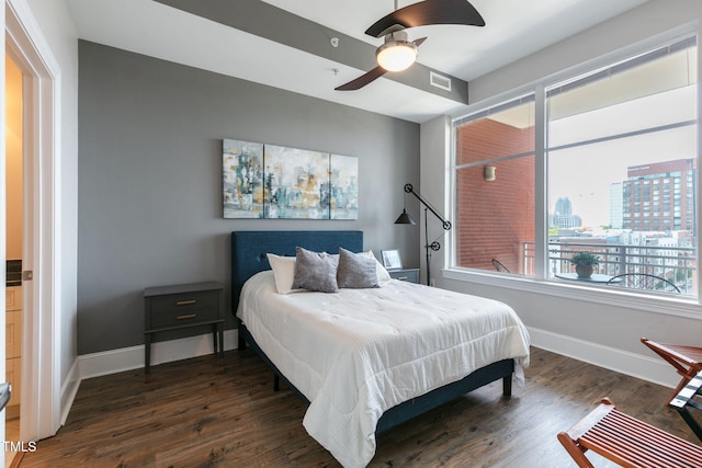 bedroom with baseboards, ceiling fan, wood finished floors, and visible vents