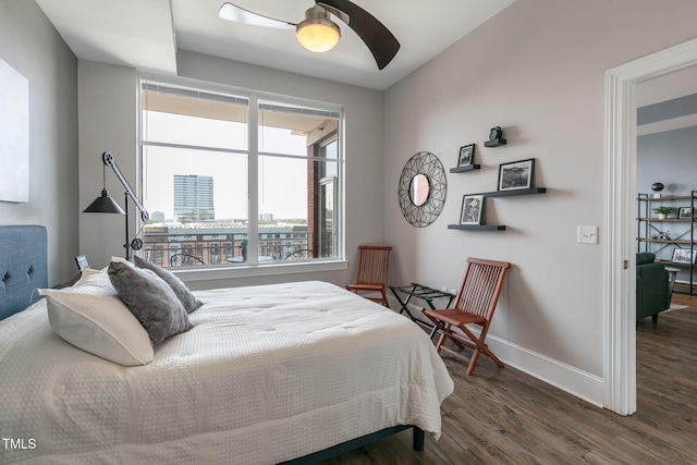 bedroom with a ceiling fan, baseboards, and wood finished floors