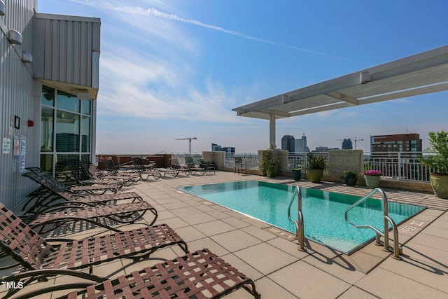 community pool with a patio and fence