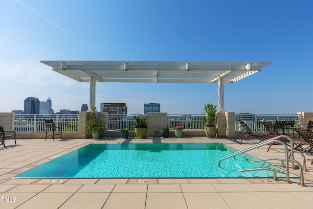 community pool with a patio area and fence
