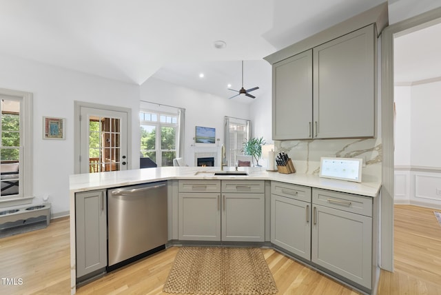 kitchen featuring a sink, gray cabinets, a peninsula, and dishwasher