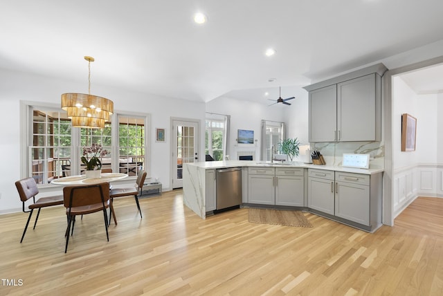 kitchen with a sink, gray cabinets, stainless steel dishwasher, and a peninsula