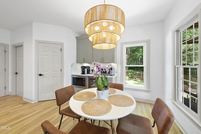 dining space with light wood-style floors, baseboards, and a chandelier