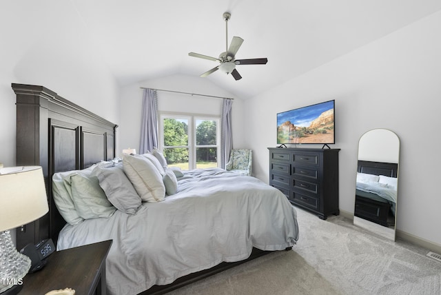 bedroom featuring light colored carpet, baseboards, ceiling fan, and lofted ceiling