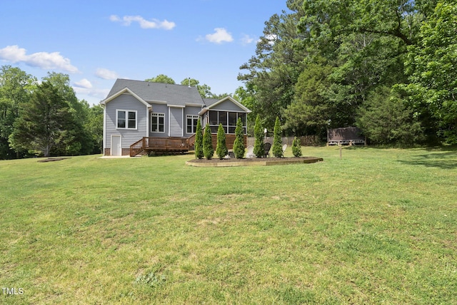 back of house with a yard, a wooden deck, and a sunroom