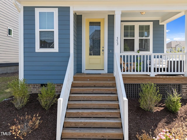 view of exterior entry featuring covered porch