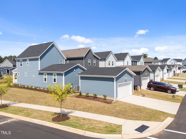 view of front of property with driveway, central AC, a front yard, and a residential view