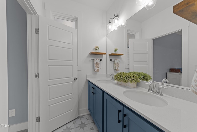 full bathroom with double vanity, a sink, baseboards, and tile patterned floors