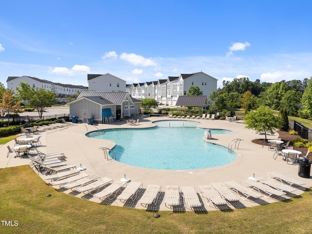 pool with fence, a patio, and a lawn