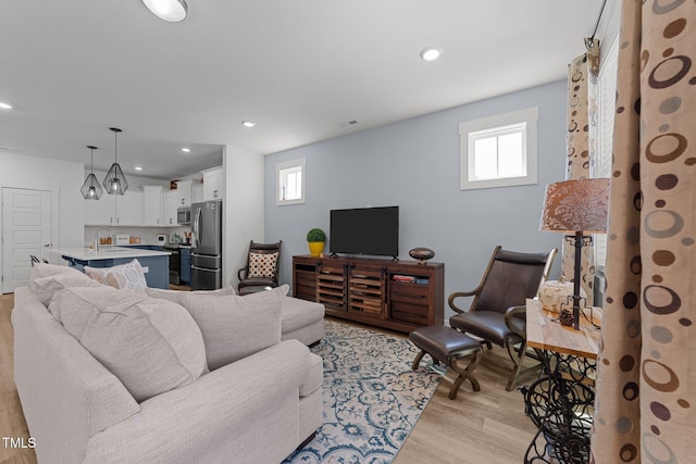 living area with recessed lighting and light wood-type flooring