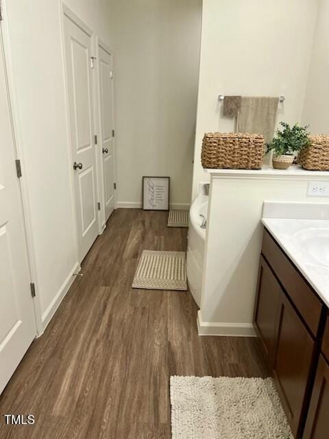 bathroom with baseboards, wood finished floors, and vanity