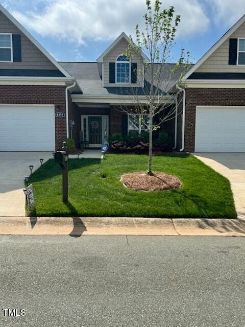 view of front of house featuring a front lawn, brick siding, driveway, and a garage