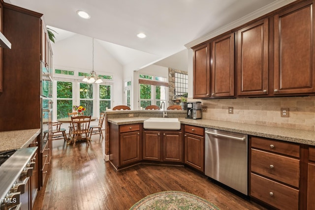 kitchen featuring appliances with stainless steel finishes, a sink, dark wood-style flooring, a peninsula, and lofted ceiling