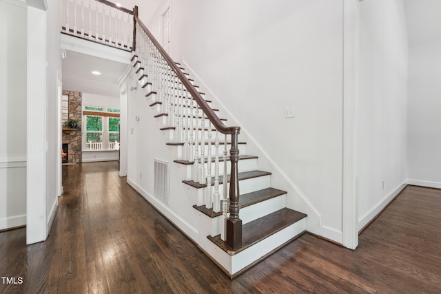 staircase featuring wood finished floors, baseboards, and recessed lighting