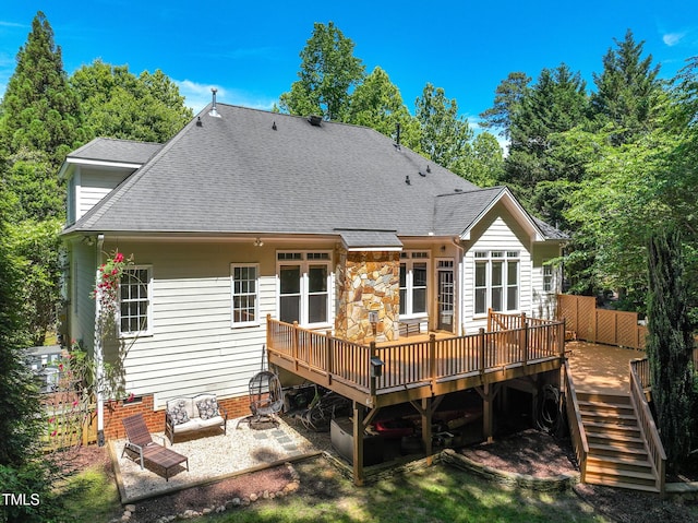 back of house with a wooden deck, a shingled roof, a patio, and stairs