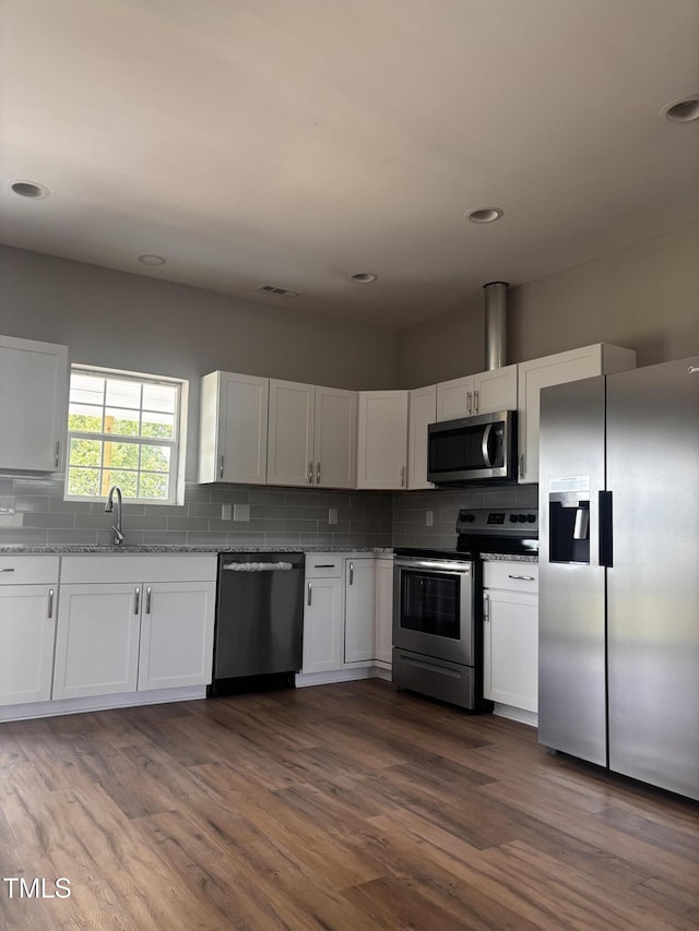 5029 Carole Dr, Wilson, NC 27893 - kitchen with stainless steel appliances, a sink, white cabinetry, decorative backsplash, and recessed lighting
