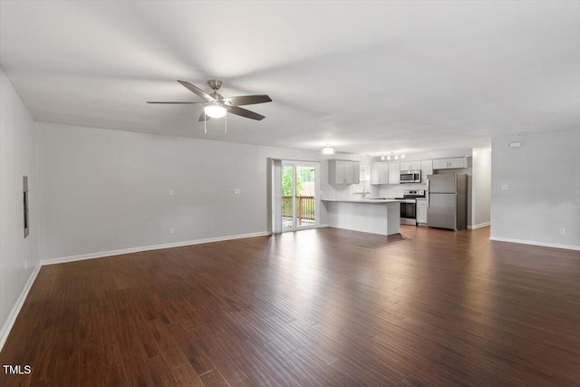 5613 Deerborn Dr, Apex, NC 27539 - unfurnished living room with dark wood-type flooring, baseboards, and ceiling fan