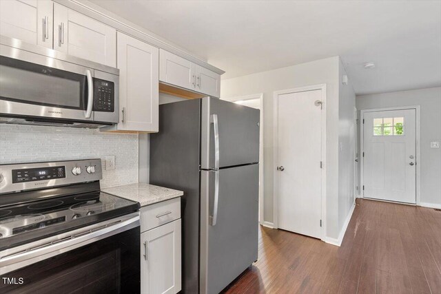 5613 Deerborn Dr, Apex, NC 27539 - kitchen featuring stainless steel appliances, white cabinetry, dark wood-style flooring, baseboards, and decorative backsplash