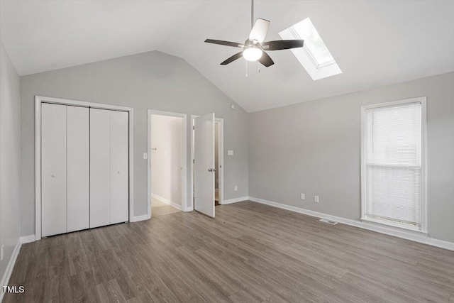 5613 Deerborn Dr, Apex, NC 27539 - unfurnished bedroom featuring a closet, baseboards, lofted ceiling with skylight, visible vents, and wood finished floors