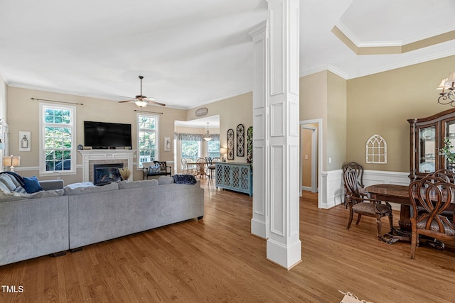 95 Live Oak Dr, Louisburg, NC 27549 - living room with a chandelier, a ceiling fan, crown molding, light wood-type flooring, and a glass covered fireplace